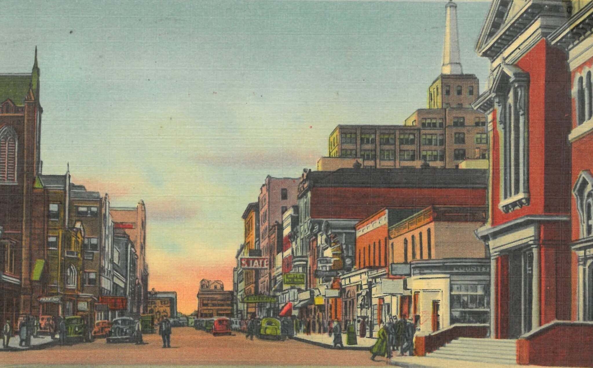 A linen postcard of the same block: shopfronts and theatre marquees line the street, with cars parked along both kerbs and a beacon on the tower closing the view.